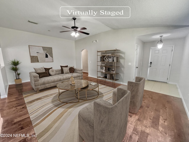 living room with arched walkways, visible vents, ceiling fan, wood finished floors, and baseboards