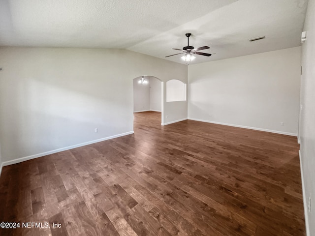 unfurnished room with ceiling fan, vaulted ceiling, dark hardwood / wood-style flooring, and a textured ceiling