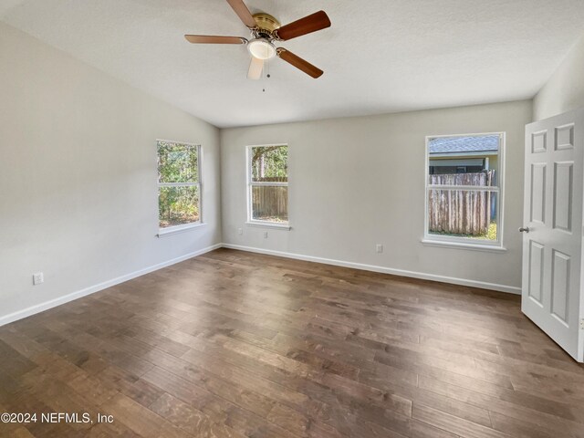 spare room with ceiling fan, lofted ceiling, dark hardwood / wood-style floors, and a healthy amount of sunlight