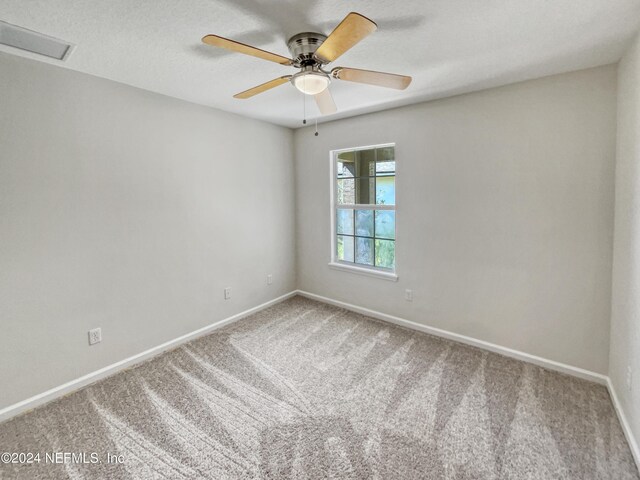 carpeted spare room with ceiling fan