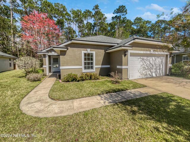 view of front of home featuring a front yard and a garage