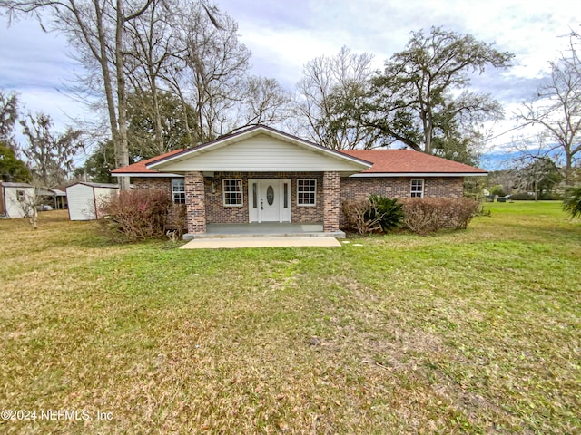 rear view of house featuring an outdoor structure and a lawn