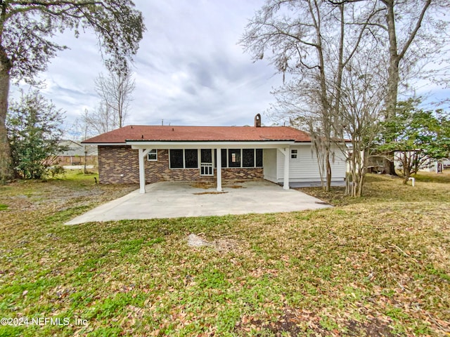 rear view of property with a lawn and a patio area