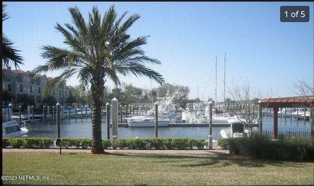 view of dock featuring a water view and a lawn