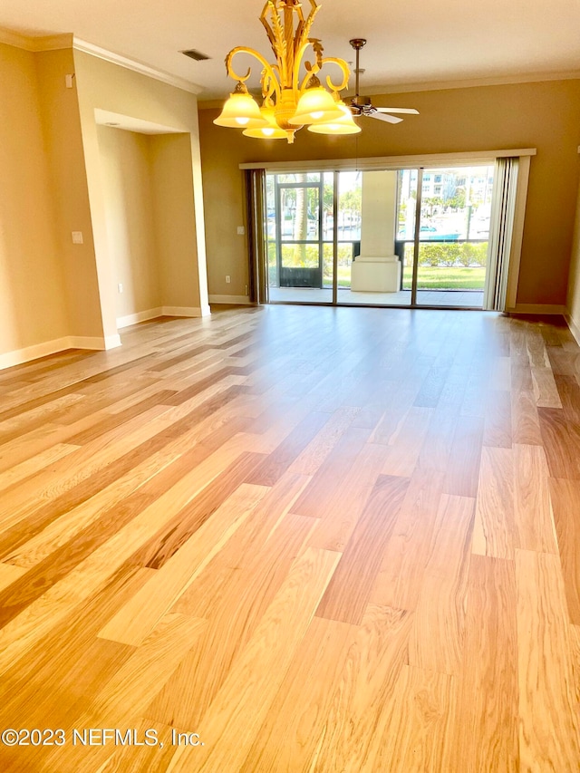 empty room featuring a healthy amount of sunlight, ornamental molding, and light wood-type flooring