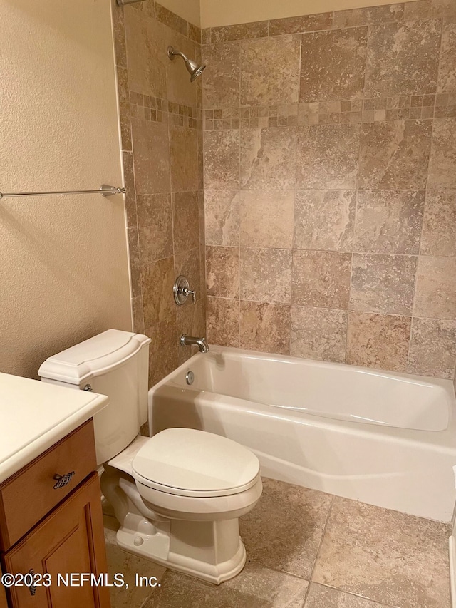 full bathroom featuring tiled shower / bath combo, tile floors, toilet, and vanity