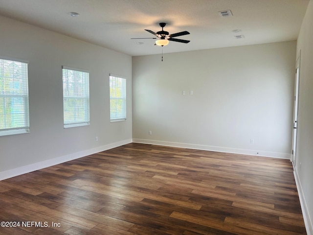 unfurnished room with dark hardwood / wood-style flooring and ceiling fan