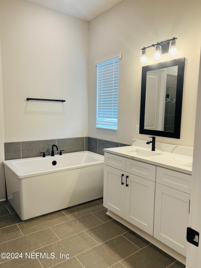 bathroom featuring a bath to relax in, tile floors, and oversized vanity