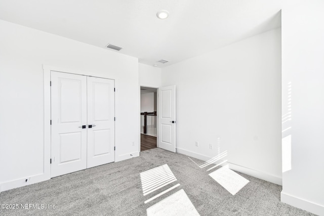 unfurnished bedroom featuring light colored carpet and a closet