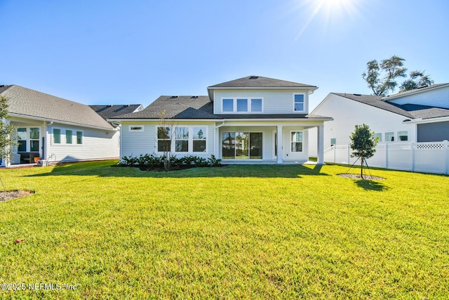 rear view of house featuring a yard