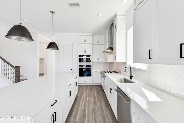 kitchen featuring sink, light stone counters, stainless steel dishwasher, pendant lighting, and white cabinets