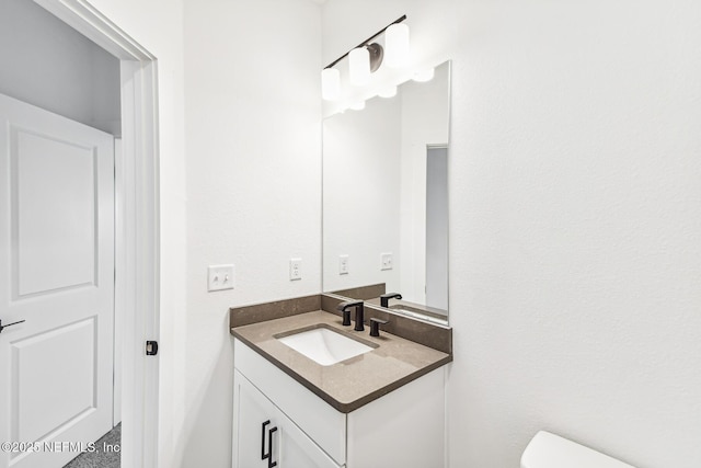 bathroom featuring vanity and toilet