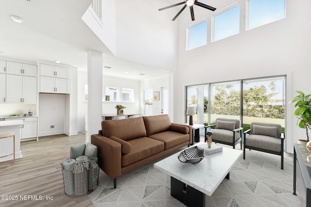 living room featuring ceiling fan and light hardwood / wood-style floors