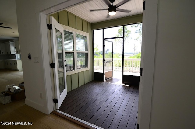 unfurnished sunroom with ceiling fan