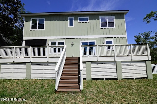 rear view of house with a lawn and a deck