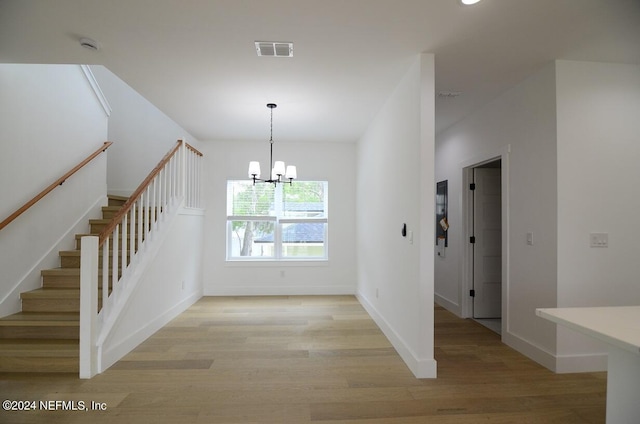 stairs with a notable chandelier and wood-type flooring