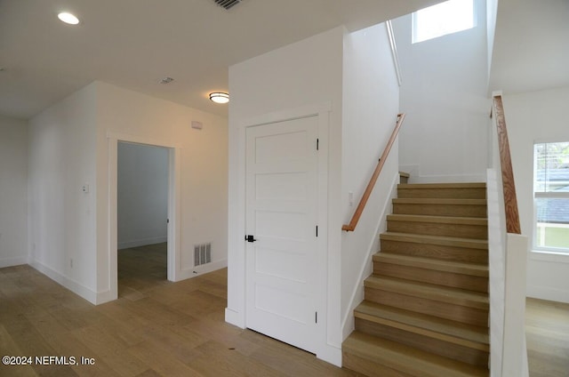 stairs with a skylight and wood-type flooring