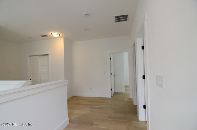 corridor with light hardwood / wood-style floors