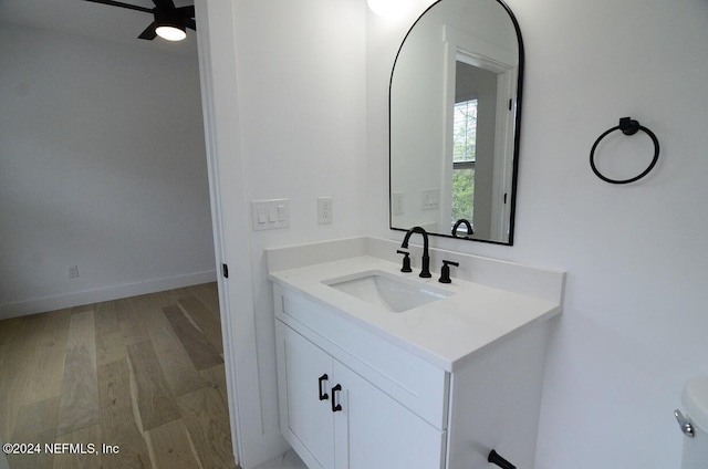 bathroom with wood-type flooring, vanity, and ceiling fan