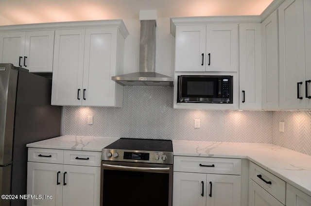 kitchen with white cabinetry, wall chimney range hood, backsplash, and appliances with stainless steel finishes