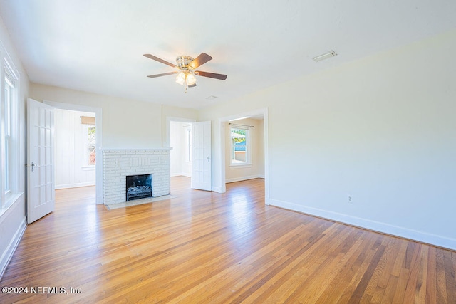 unfurnished living room with light hardwood / wood-style floors, ceiling fan, and a fireplace