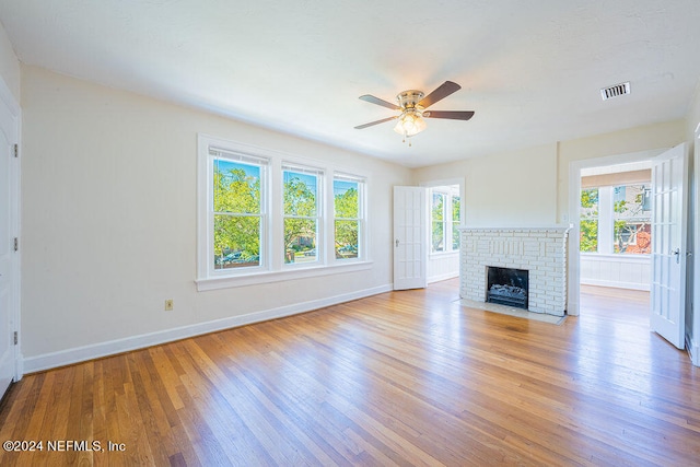 unfurnished living room featuring ceiling fan, light wood-type flooring, and a fireplace