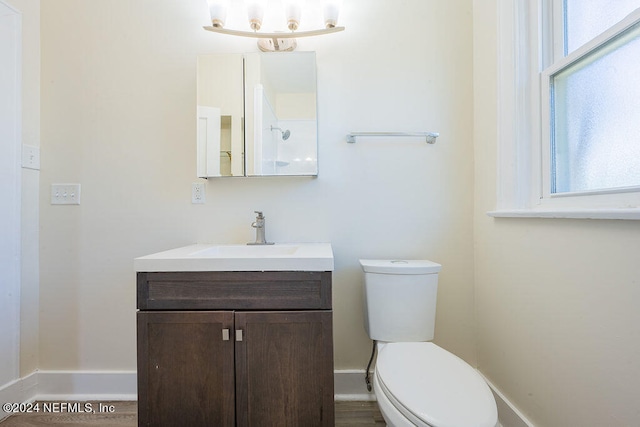 bathroom with hardwood / wood-style flooring, toilet, and vanity