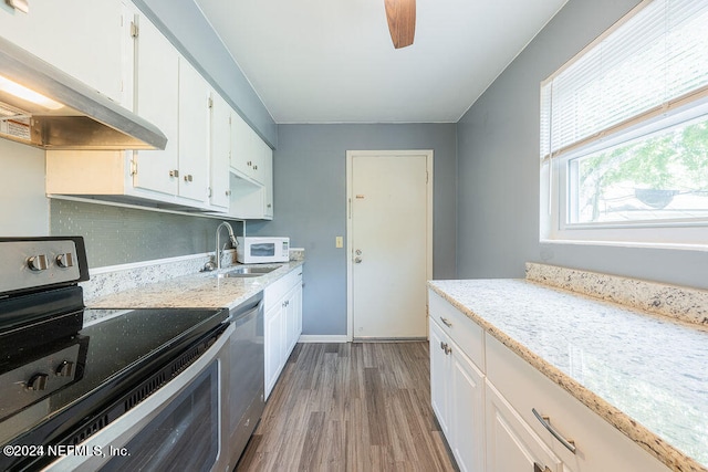 kitchen with wall chimney exhaust hood, wood-type flooring, stainless steel appliances, and white cabinetry