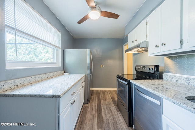 kitchen with appliances with stainless steel finishes, white cabinetry, backsplash, and ceiling fan