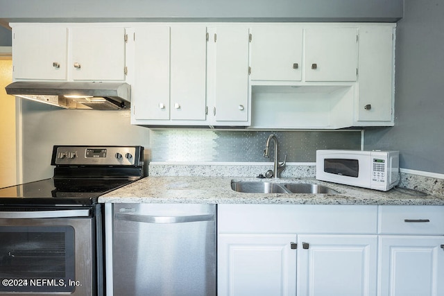 kitchen featuring light stone countertops, backsplash, sink, stainless steel appliances, and white cabinets