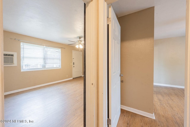 hall featuring a wall unit AC and light wood-type flooring