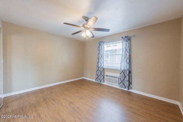 spare room featuring a wall mounted air conditioner, light hardwood / wood-style floors, and ceiling fan