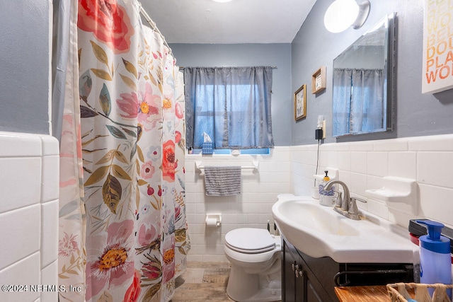 bathroom featuring tile walls, tasteful backsplash, toilet, and vanity