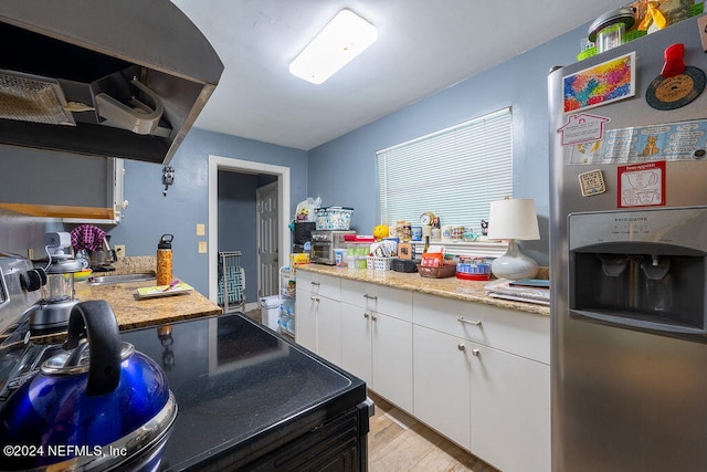 kitchen featuring white cabinets, stainless steel fridge with ice dispenser, light hardwood / wood-style flooring, and light stone counters