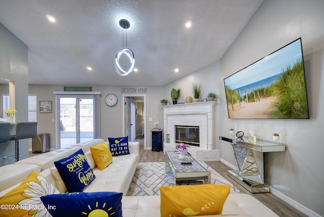 living room featuring light hardwood / wood-style floors, a textured ceiling, and a fireplace