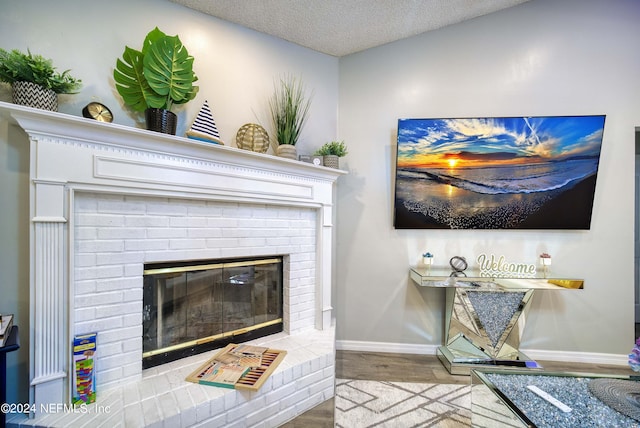 living room with a fireplace, a textured ceiling, and light wood-type flooring