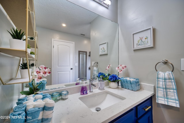 bathroom featuring a textured ceiling and vanity