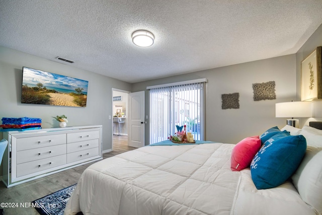 bedroom with a textured ceiling and light hardwood / wood-style floors