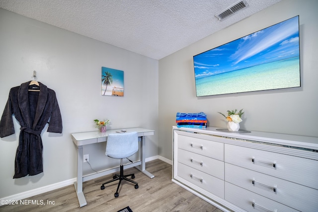 office space featuring light hardwood / wood-style floors and a textured ceiling