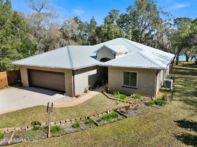 ranch-style home with a front yard, central AC, and a garage