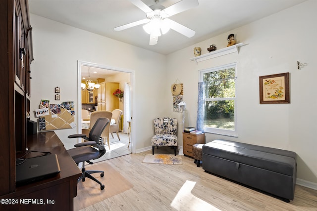 office space with ceiling fan with notable chandelier and light wood-type flooring