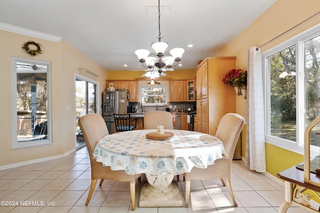 dining room with light tile flooring, ornamental molding, and ceiling fan with notable chandelier