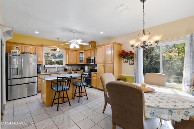 kitchen with pendant lighting, tasteful backsplash, ceiling fan with notable chandelier, and stainless steel appliances