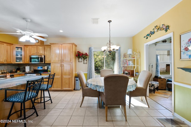 dining area featuring light tile floors and ceiling fan with notable chandelier