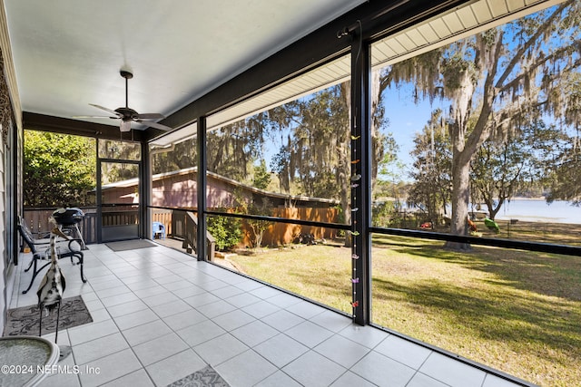 unfurnished sunroom featuring ceiling fan