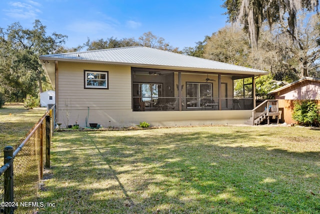 rear view of house with a lawn and ceiling fan