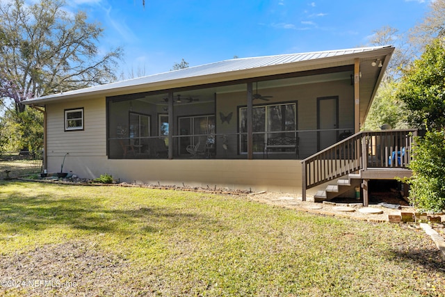 rear view of property featuring a lawn and a sunroom