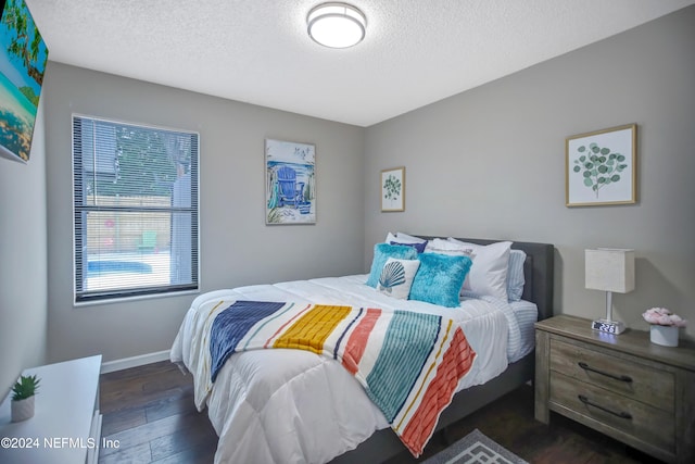 bedroom with dark hardwood / wood-style flooring and a textured ceiling