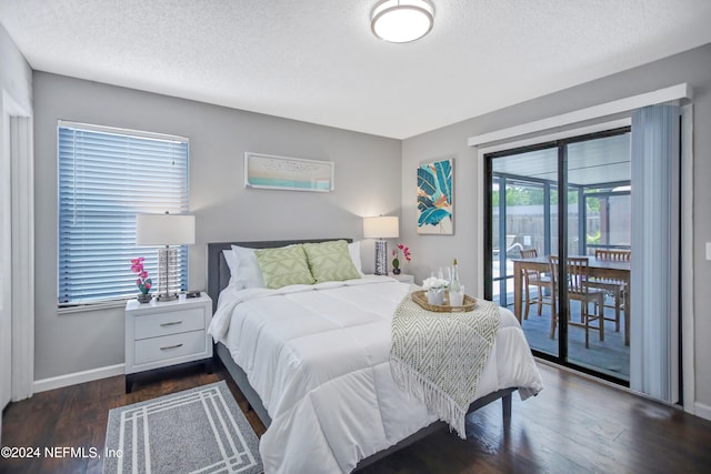 bedroom with dark hardwood / wood-style floors, access to outside, and a textured ceiling