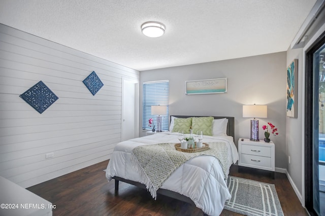 bedroom with dark hardwood / wood-style floors and a textured ceiling